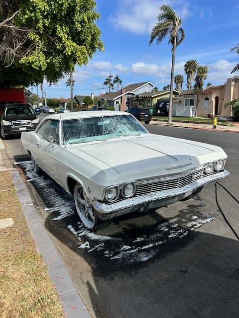 Classic silver sedan getting a hand foam wash